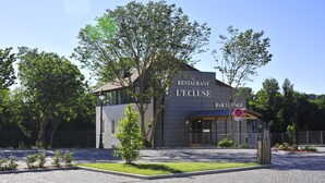 A modern building with a sign reading "RESTAURANT L'ECLUSE BAR LOUNGE".