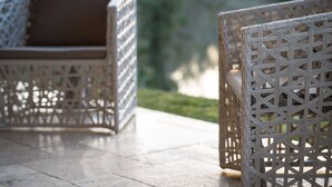Wicker outdoor furniture with a cushion on a patio.