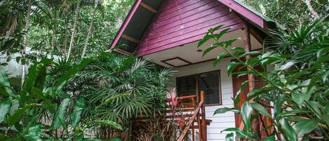 A small, rustic building surrounded by dense tropical vegetation.