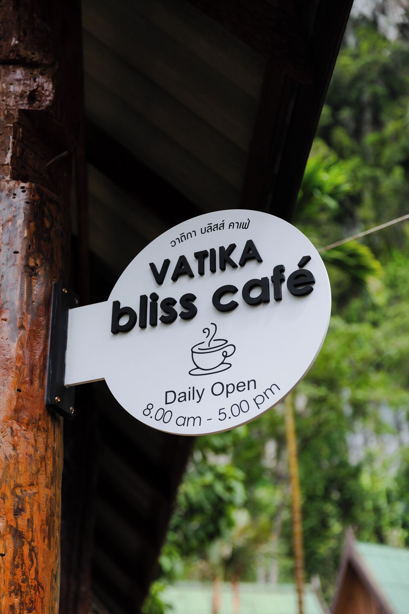 Une enseigne indiquant le café Vatika Bliss, avec les heures d’ouverture : de 8h00 à 17h00.