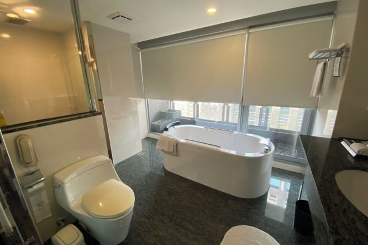 A modern bathroom with a bathtub, toilet, and sink.