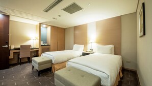 A hotel room with two beds, a desk, a chair, and a small table with a lamp. - CHECK inn Select Taichung Dadun (Taichung)