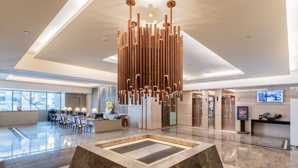 A modern lobby with a central water feature, a reception desk, and a seating area. - CHECK inn Select Taichung Dadun (Taichung)