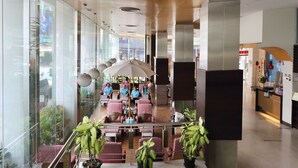 A spacious indoor area with a seating area, potted plants, and a view of the outside through large windows. - Golden Crown Grand Hotel (Hat Yai)
