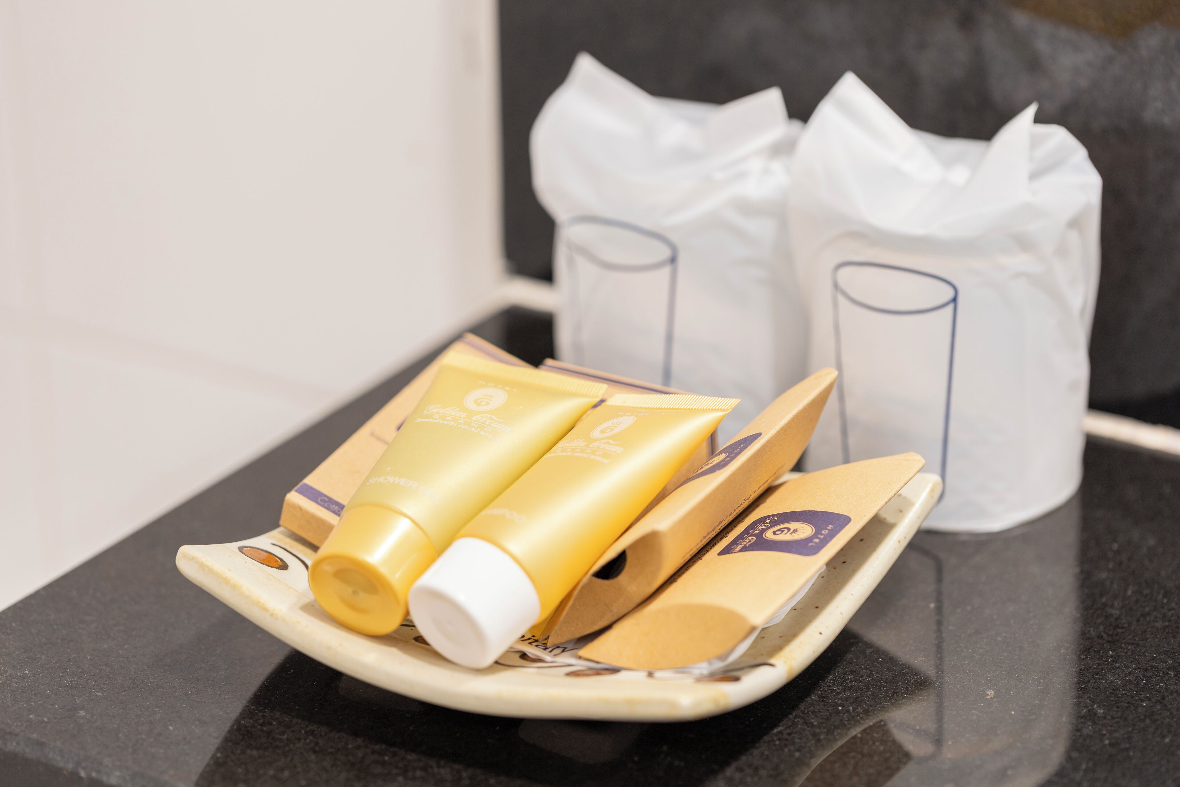 A tray with skincare products and a tissue box on a reflective surface.
