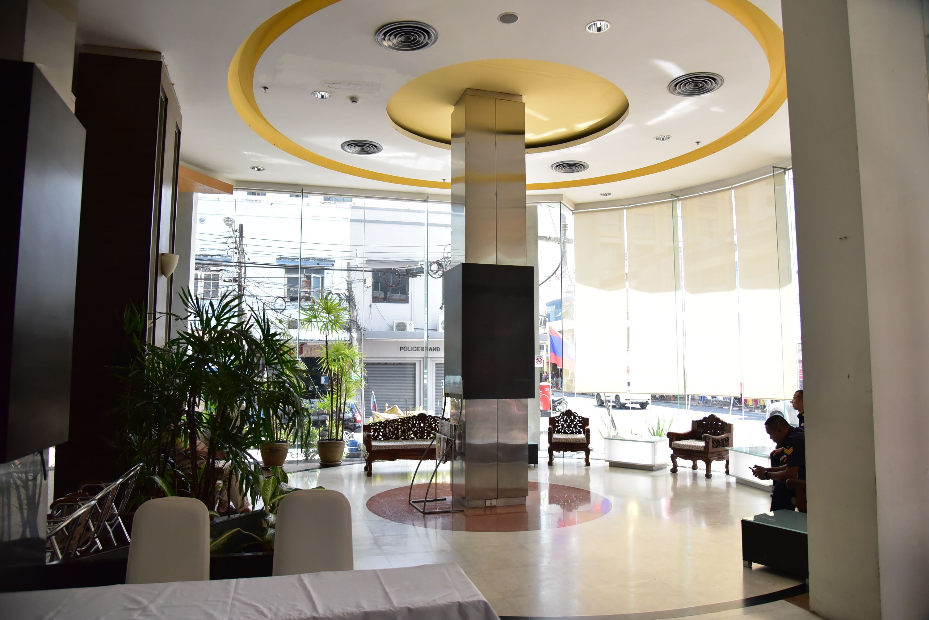 A spacious lobby with a central column, seating areas, and large windows.