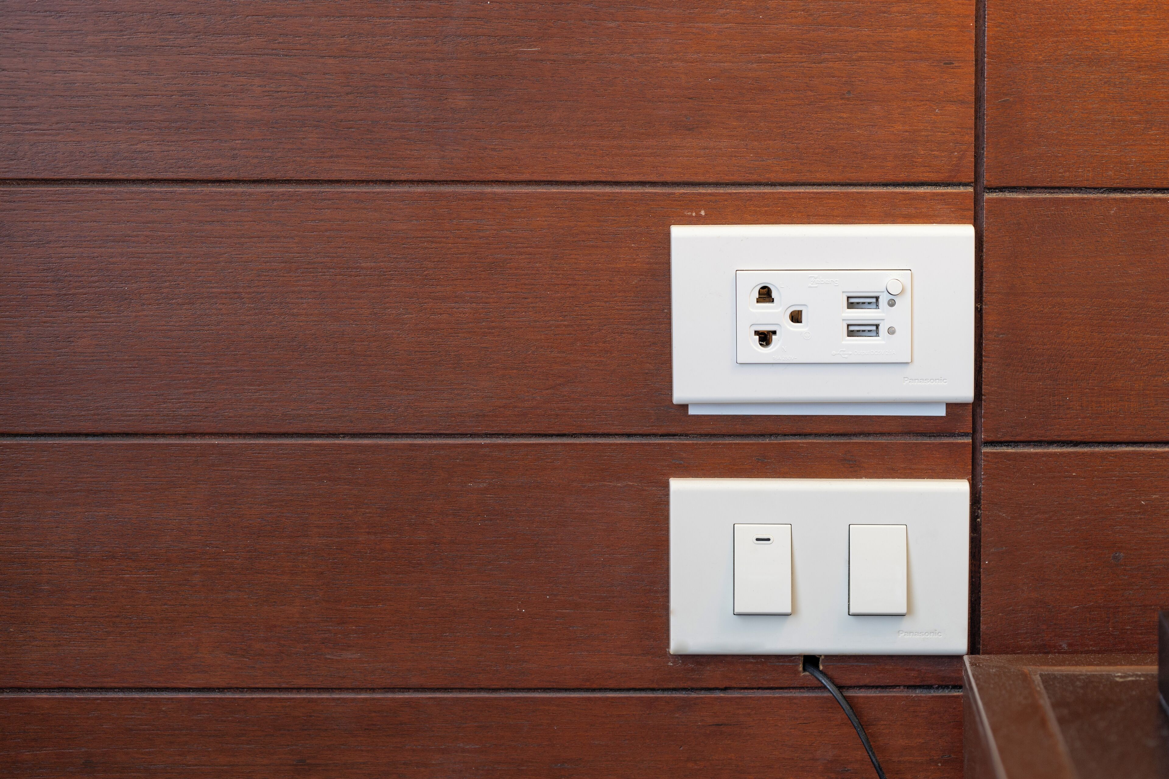 A wall with two white electrical outlets and switches, one with a USB port.