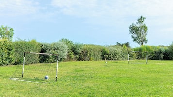 A soccer field with two goals and a ball.