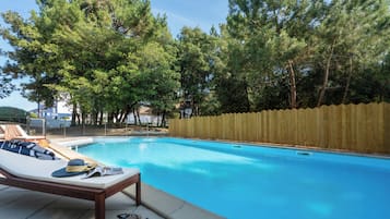 Una piscina cubierta, una piscina al aire libre de temporada, sombrillas