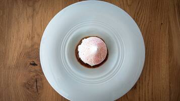 Un plato blanco con un postre sobre una mesa de madera.