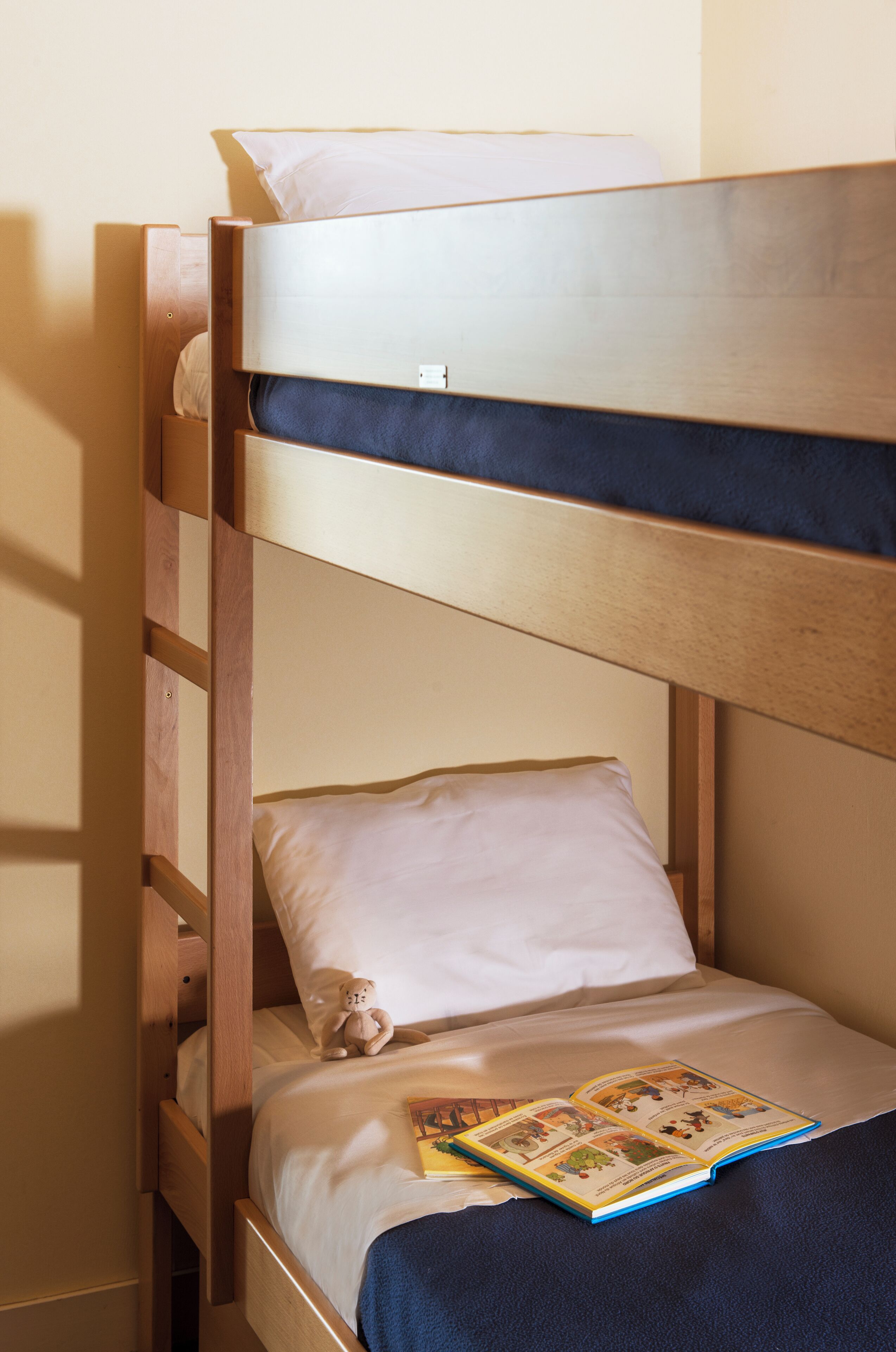 A bunk bed with a book on the lower bunk.