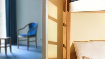 Cozy retreat with a single bed, small table, and chair, perfect for a comfortable stay.