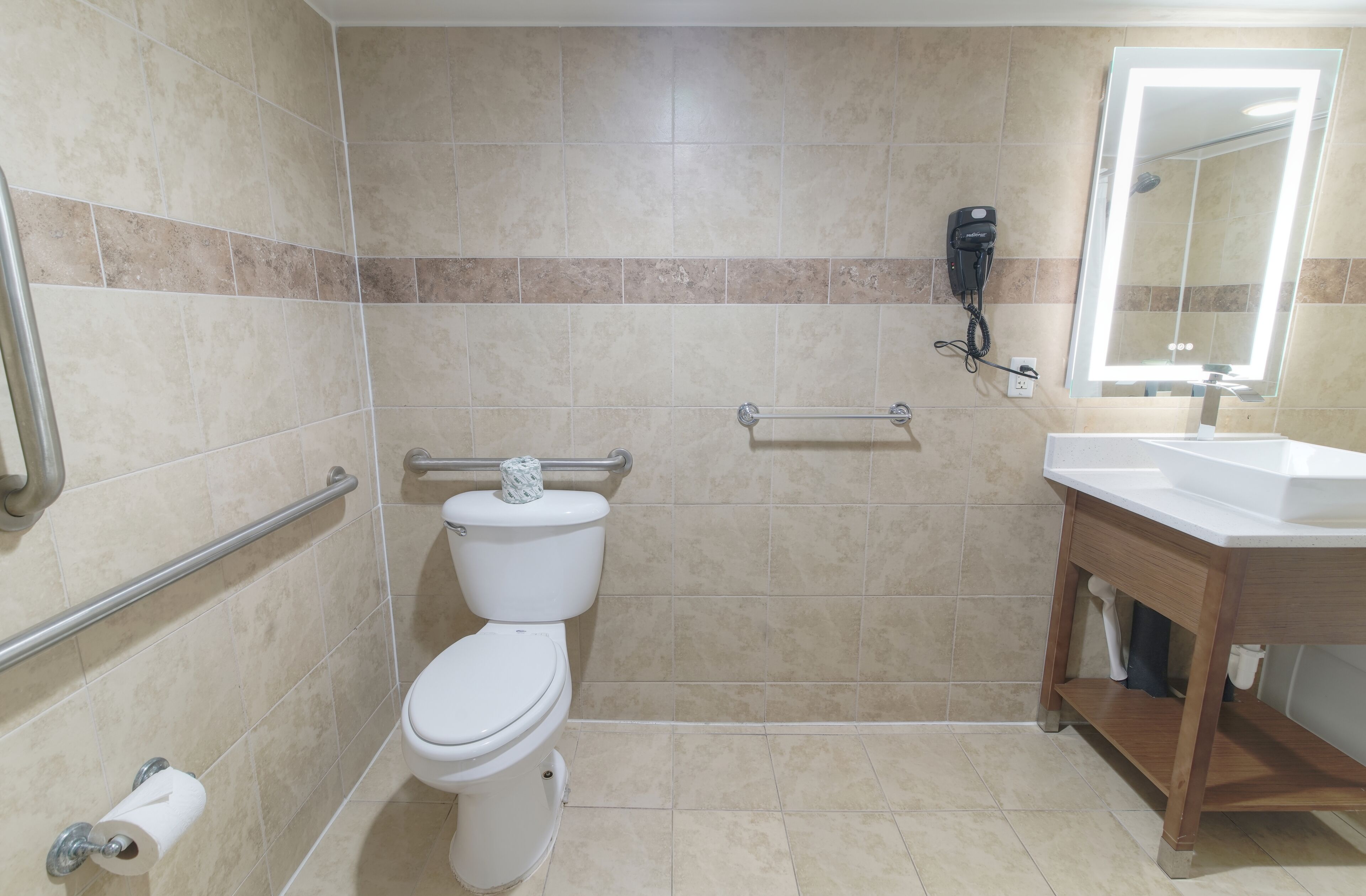 Un bagno con il water, un asciugamani ad aria e un lavandino con specchio.