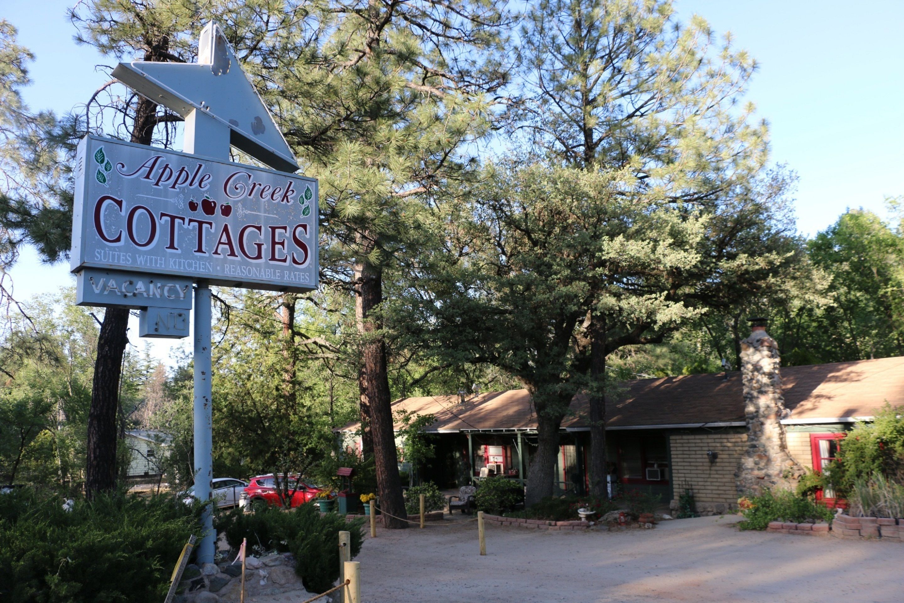 A sign for Apple Creek Cottages advertising suites with kitchen and reasonable rates.