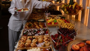 Un buffet proposant une variété de plats et une personne qui sert les clients.