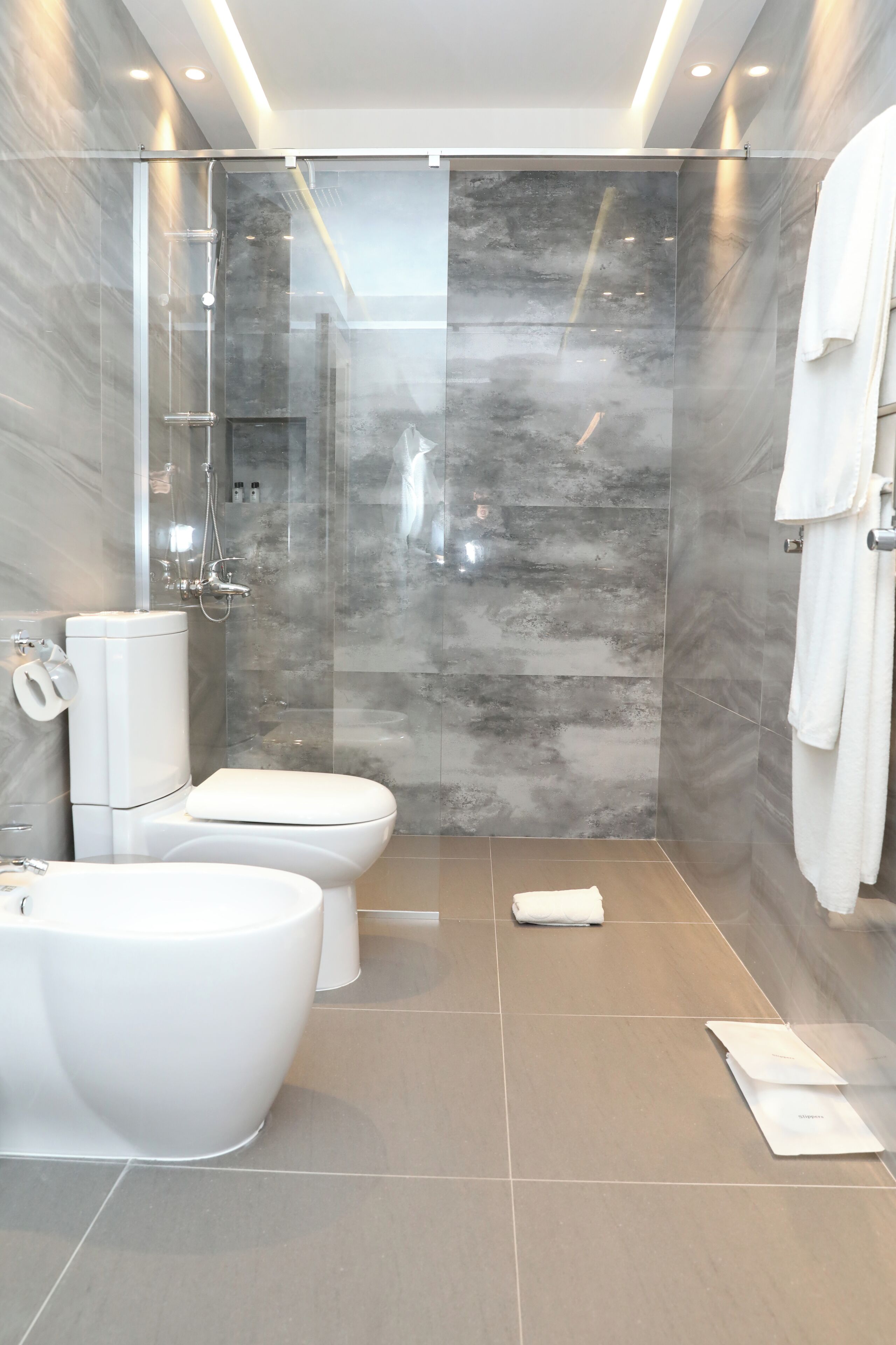 Un baño moderno con ducha de vidrio, inodoro y bañera.