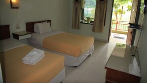 Une chambre d’hôtel avec deux lits, une table de chevet, un bureau, un miroir et un balcon donnant sur l’extérieur.
