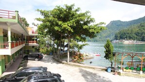 Un hôtel doté d’un parking, offrant une vue sur un lac et dont la façade est verdoyante.