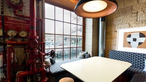 A restaurant with a large window, a table, and a bench. - Customs House Hotel (Hobart)