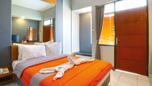 A hotel room with a bed, a telephone, a mirror, and a sliding door. - Sayang Residence 2 (Denpasar)