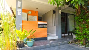 A reception area with a sign reading "SAYANG RESIDENCE RECEPTION," a clock, and potted plants. - Sayang Residence 2 (Denpasar)