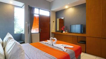 Habitación de hotel moderna con una cama grande, un televisor de pantalla plana, un armario de madera y una ventana con persianas.