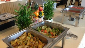 A buffet with various food options including fruits, vegetables, and a salad. - Jun Yue Hotel (Phnom Penh)