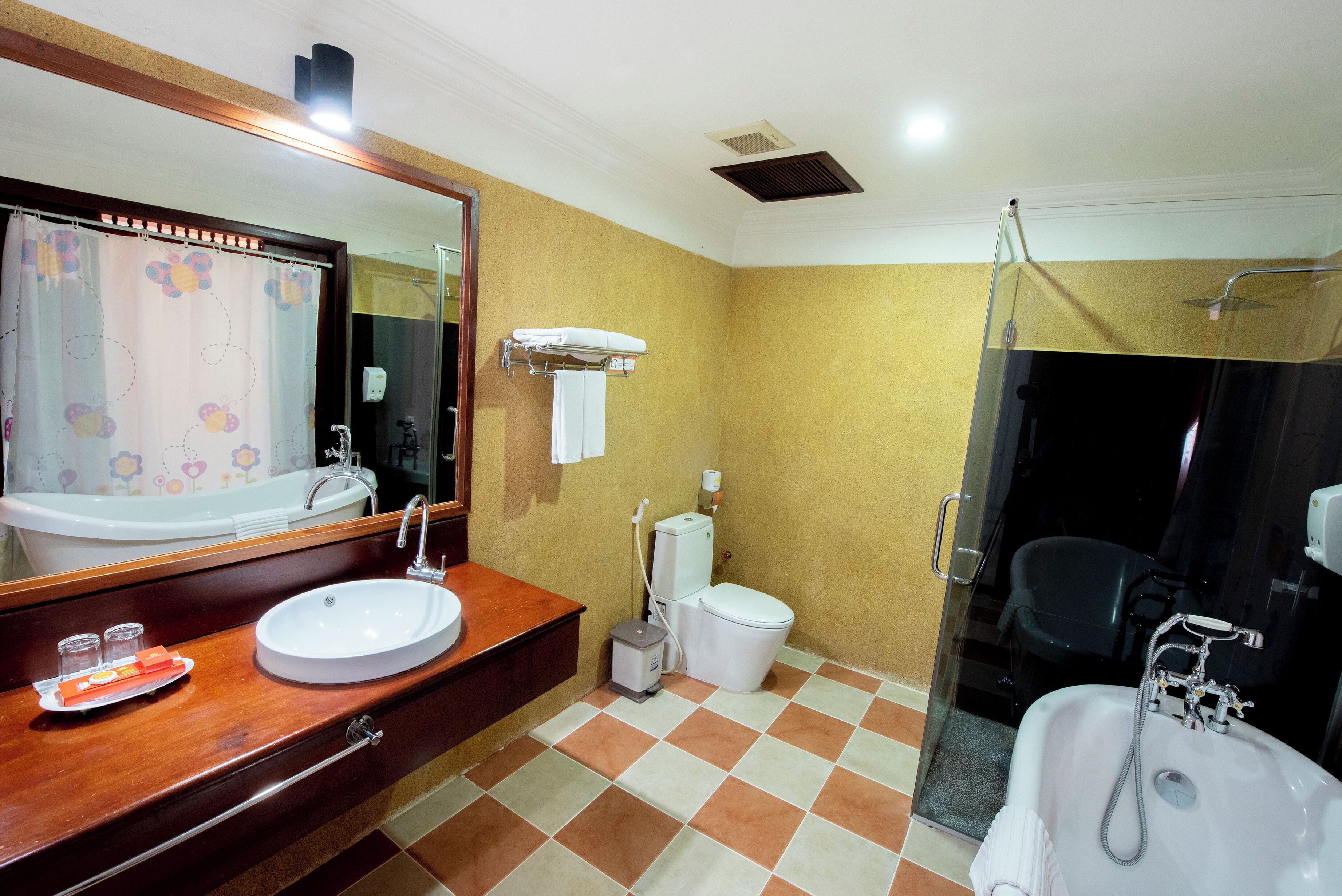 Een badkamer met een wit wastafelmeubel, een toilet en een douchehoek.