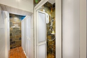 A bathroom with a shower, tiled walls, and a tiled floor. - the youniQ Hotel (Sepang)