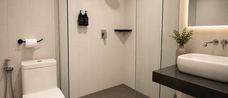 Et moderne badeværelse med toilet, bruser og vask.