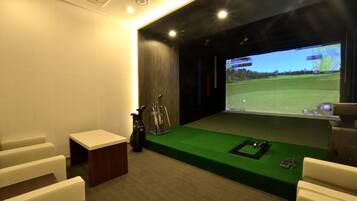 Experience golf simulation in a state-of-the-art room with a large screen, practice mat, and golf clubs.