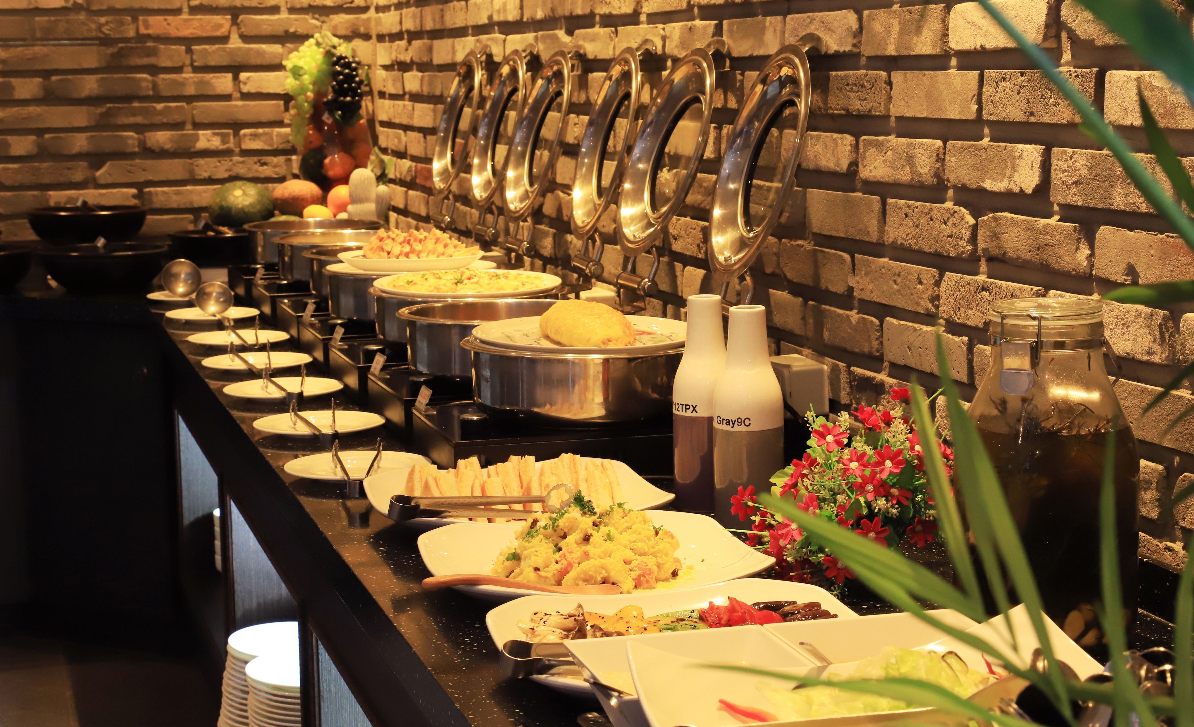 A buffet setup with various dishes and beverages.