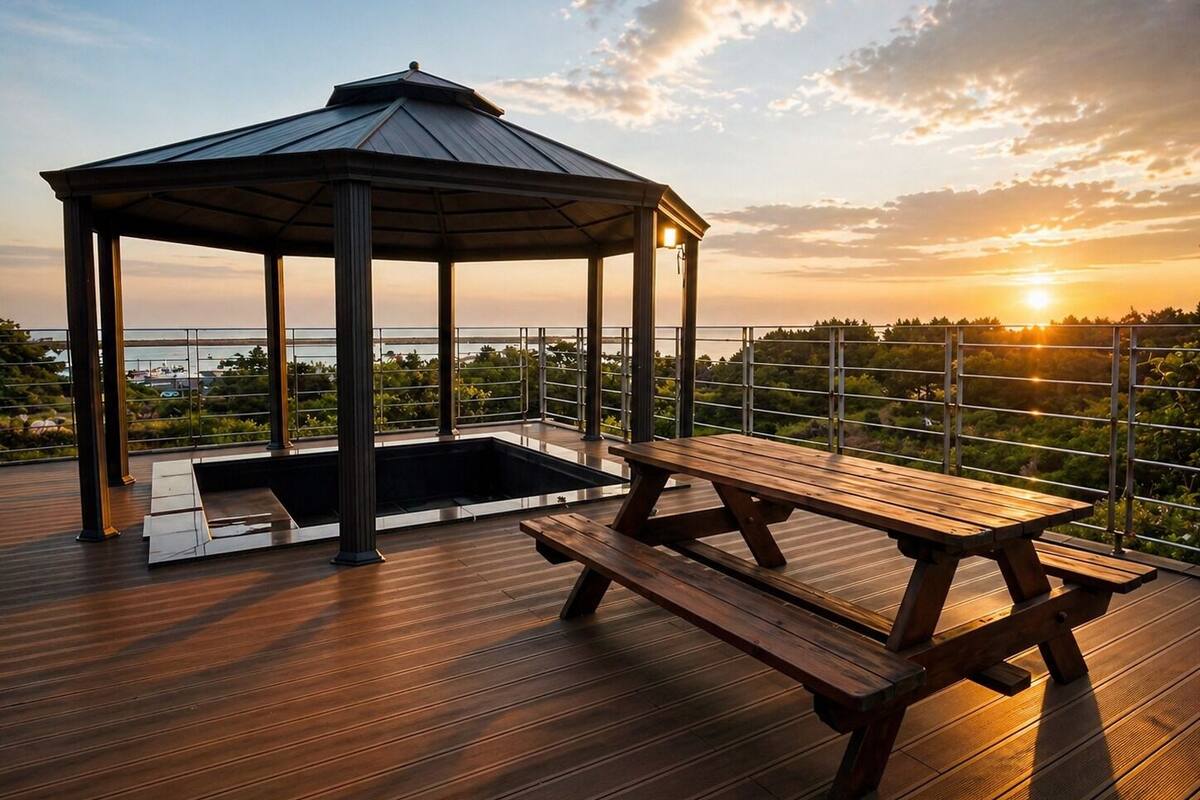 A wooden deck with a gazebo and picnic table overlooking a body of water.