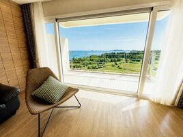 Un balcón con vistas a un paisaje verde y al mar.