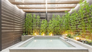 A modern indoor pool area with a rectangular pool, surrounded by wooden walls and bamboo plants. - HOTEL FORÊT THE SPA (Busan)