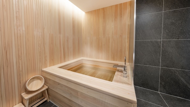 A modern bathroom with a wooden vanity, a black tiled wall, and a wooden floor. - HOTEL FORÊT THE SPA (Busan)