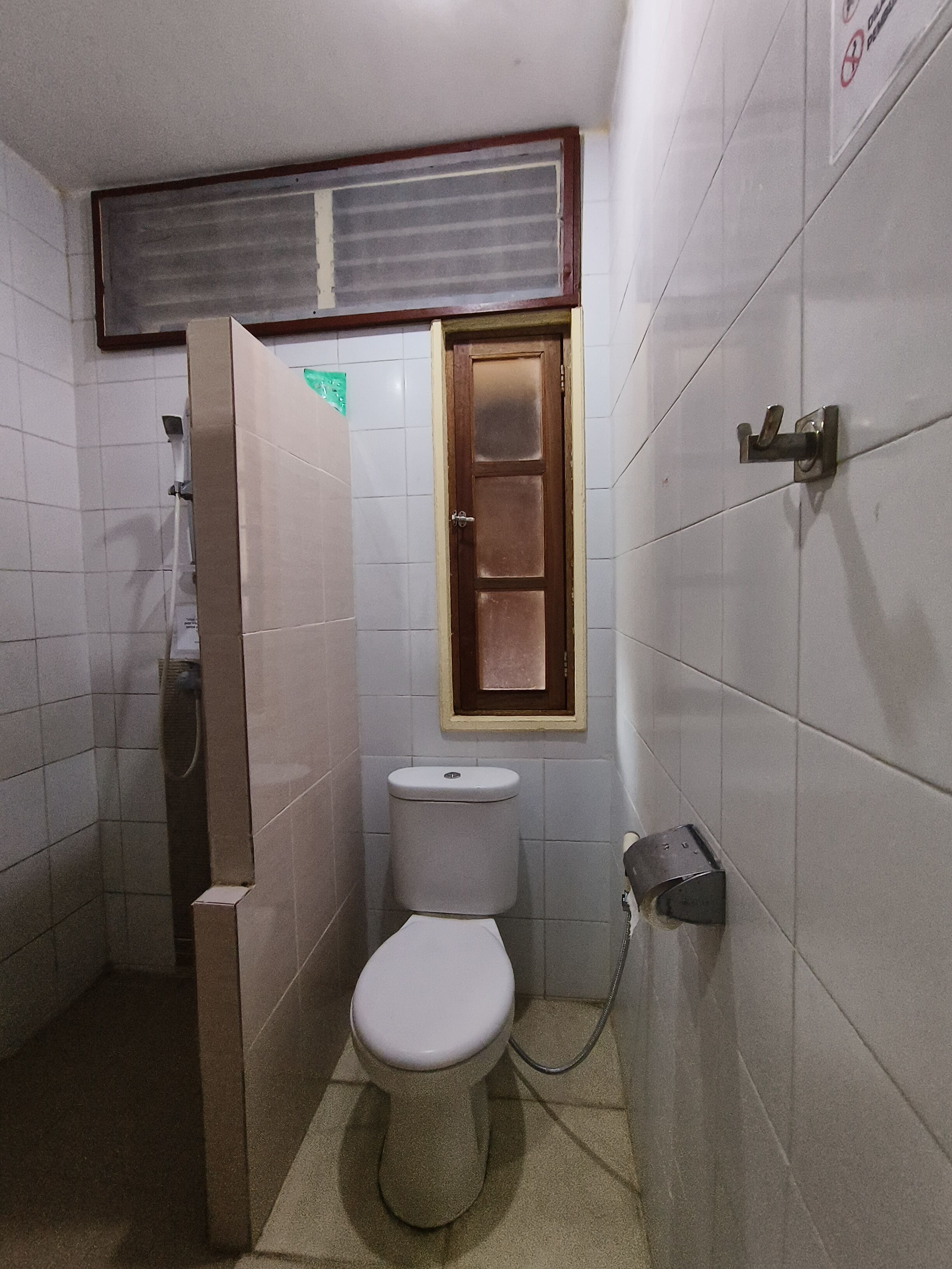 A small, compact bathroom with a toilet, a shower, and a sink.