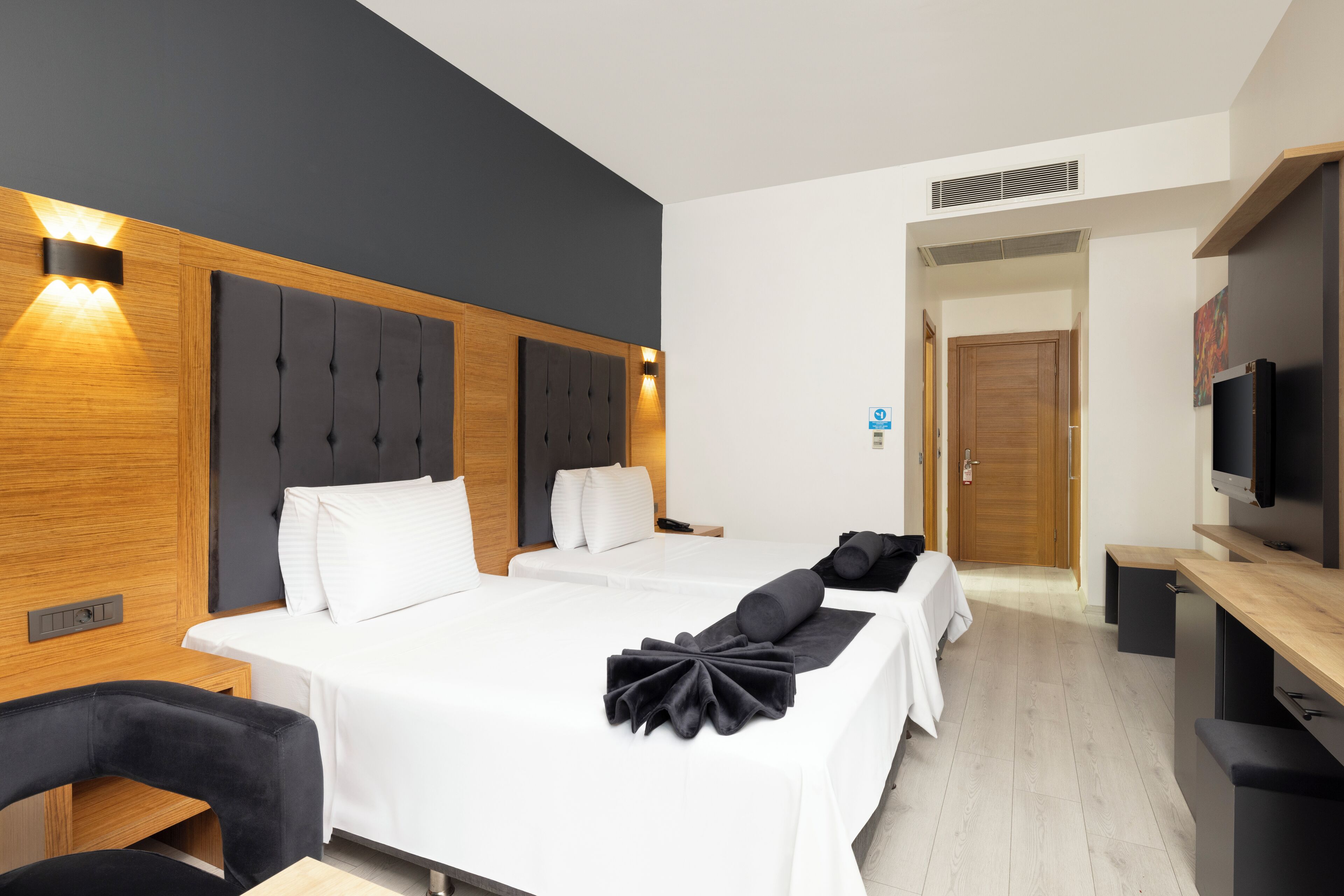 Una habitación de hotel con una cama grande, un escritorio, una silla y un televisor.