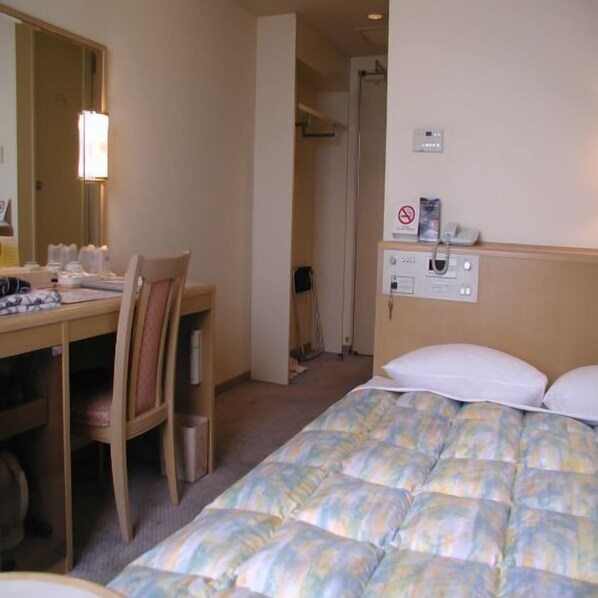 A hotel room with a bed, a desk, and a chair. There is a mirror on the wall, a nightstand, and a wall-mounted control panel. - Tsubame Sanjo Washington Hotel (Tsubame)