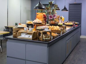 A buffet with various food items, wooden serving stations, and pendant lighting. - ibis Contagem Ceasa (Contagem)