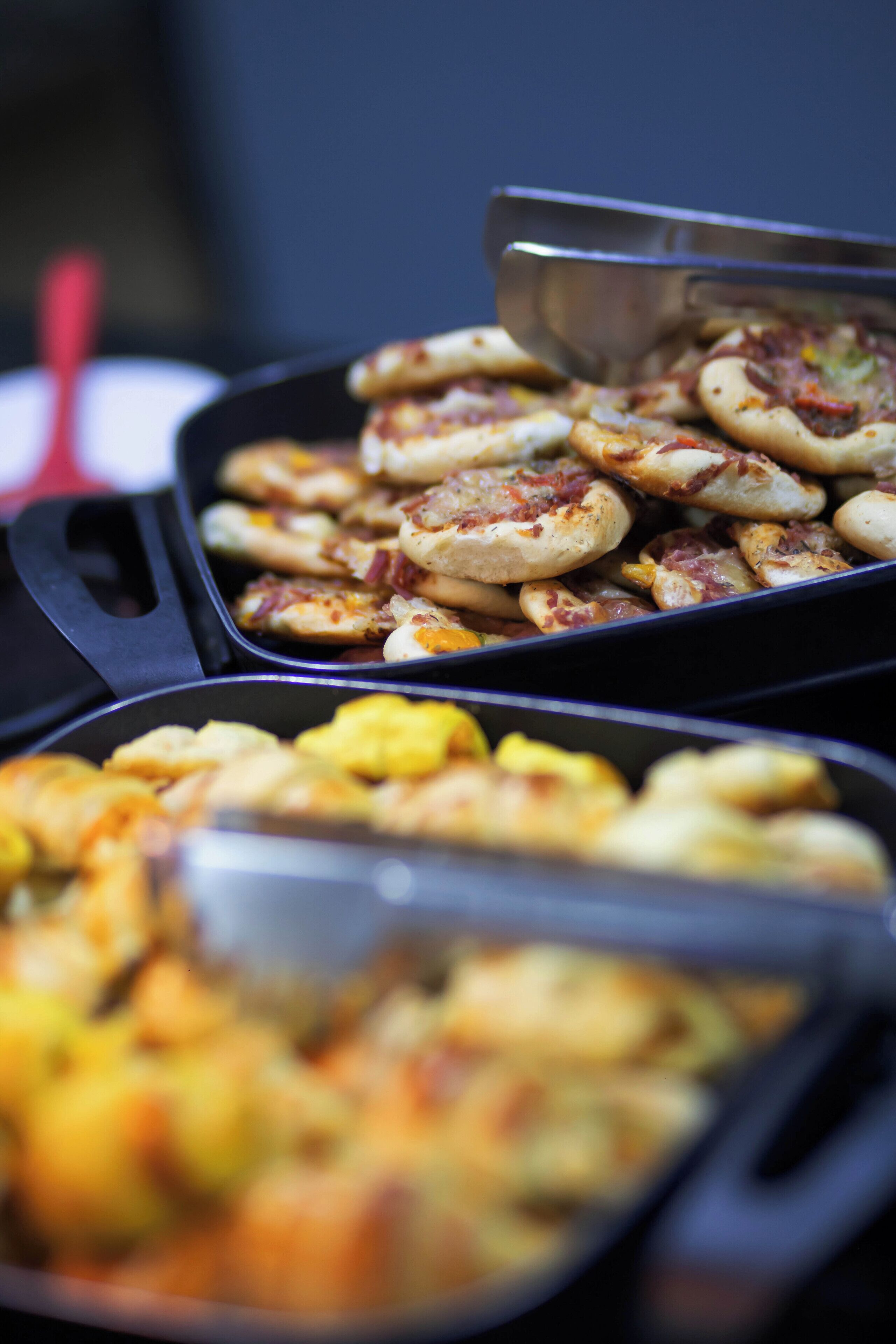 A buffet with various dishes in serving trays.