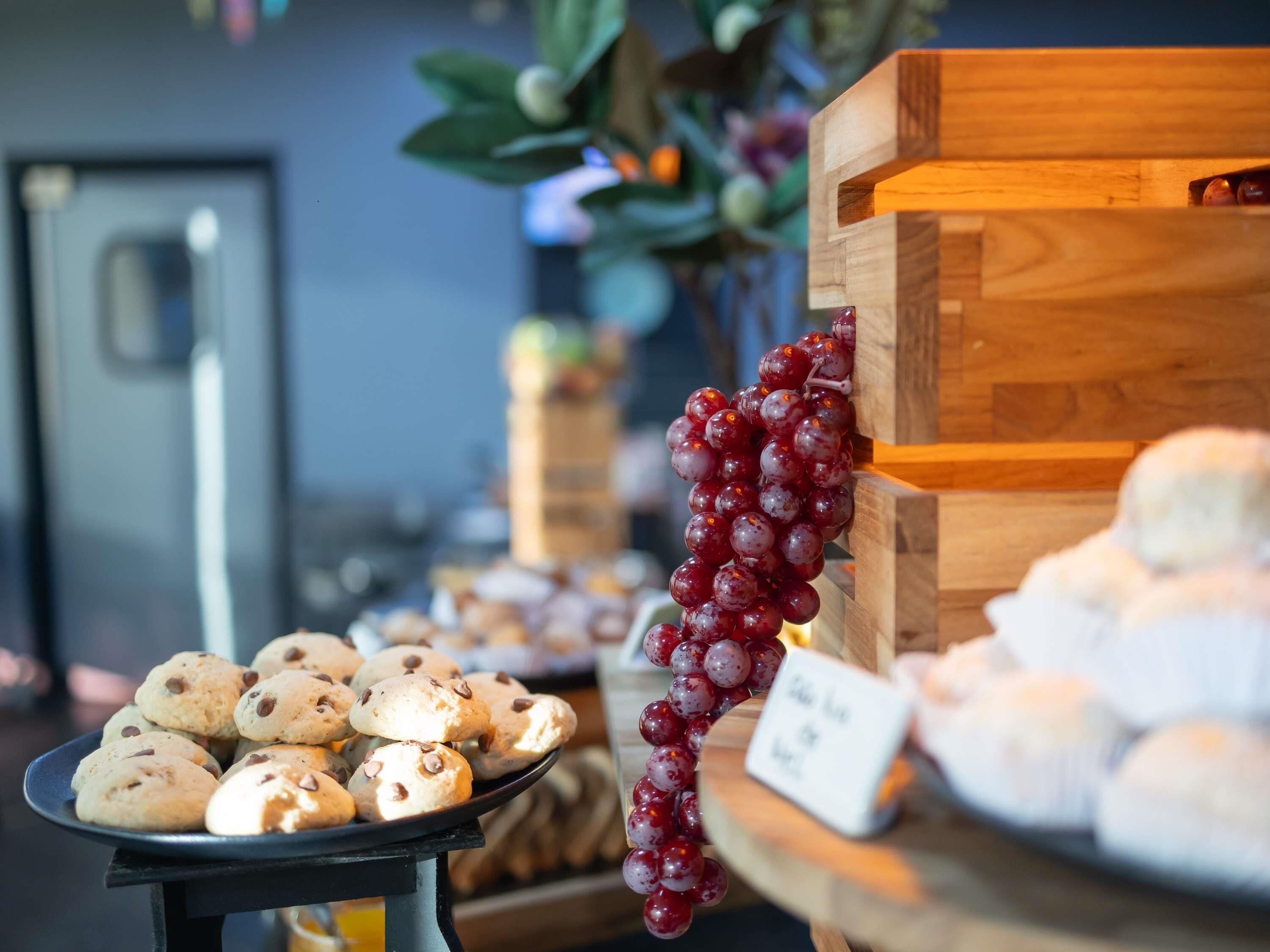 A display of cookies and grapes on a table with a sign indicating a price.