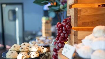 A display of cookies and grapes on a table with a sign indicating a price.