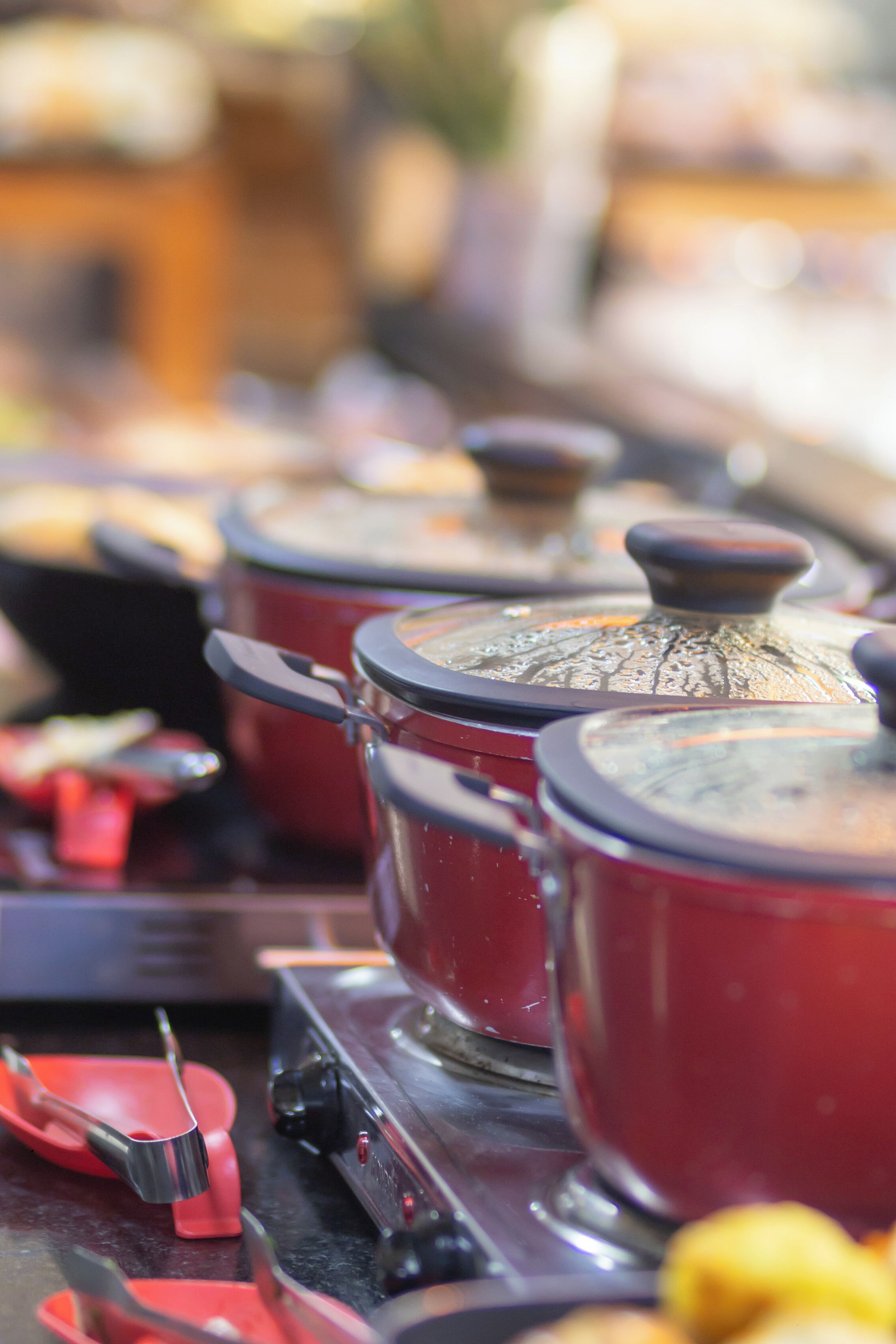 A kitchen with red pots and pans on a stove.