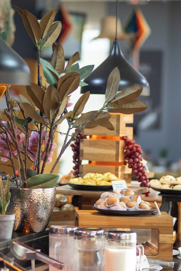 A buffet table with various food items, a glass of milk, and a decorative plant. - ibis Contagem Ceasa (Contagem)