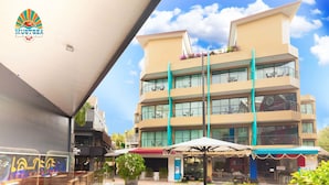 Un hotel de diseño moderno, con varios balcones con asientos exteriores y un patio central con una fuente.