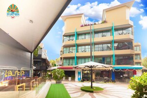 Un hotel de diseño moderno, con varios balcones con asientos exteriores y un patio central con una fuente.