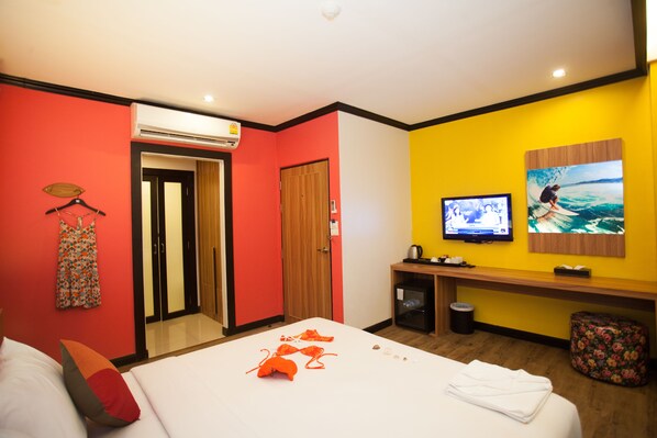 Une chambre d’hôtel avec un lit, une télévision, un bureau en bois et une salle de bain.