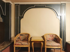 A room with two wooden chairs with floral upholstery and a small wooden table. - FuZhuang Hotel (Taipei)