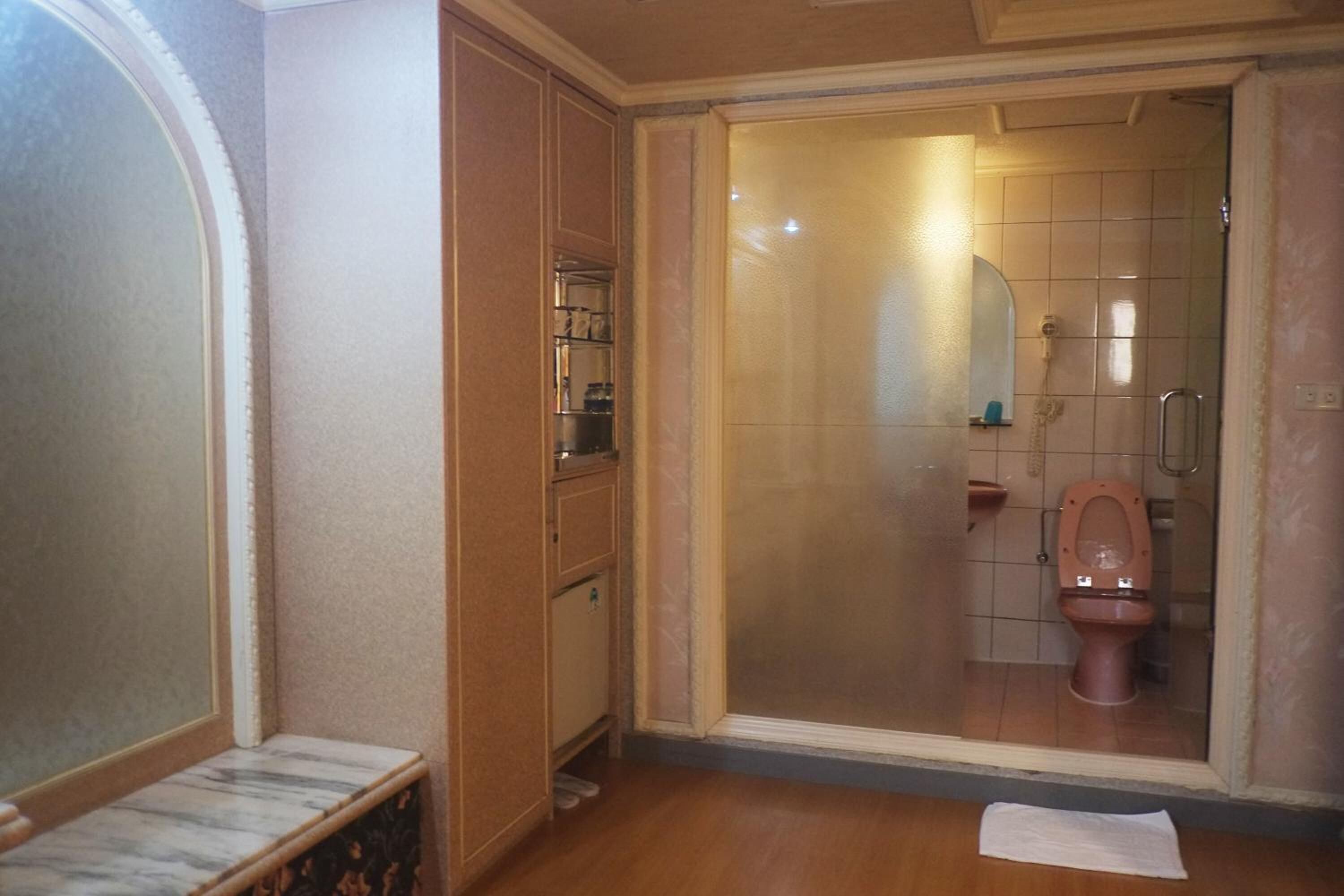 A bathroom with a glass-enclosed shower, a toilet, and a vanity with a mirror.